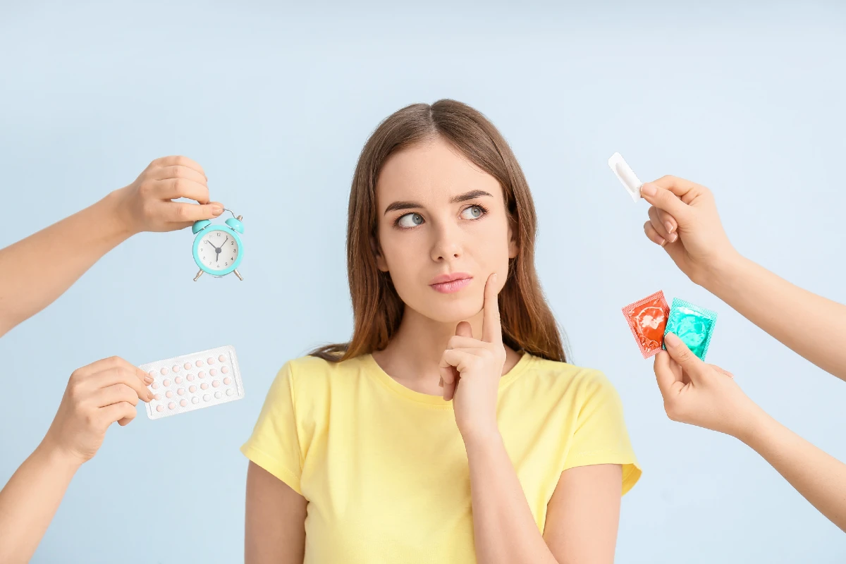 Image of a person with contraception items surrounding them with them making a thinking face.
